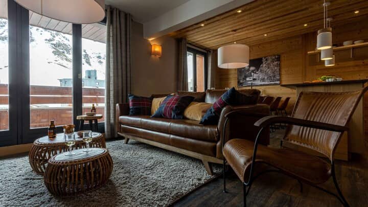 Living room with leather sofa, wood-paneled walls, and mountain views
