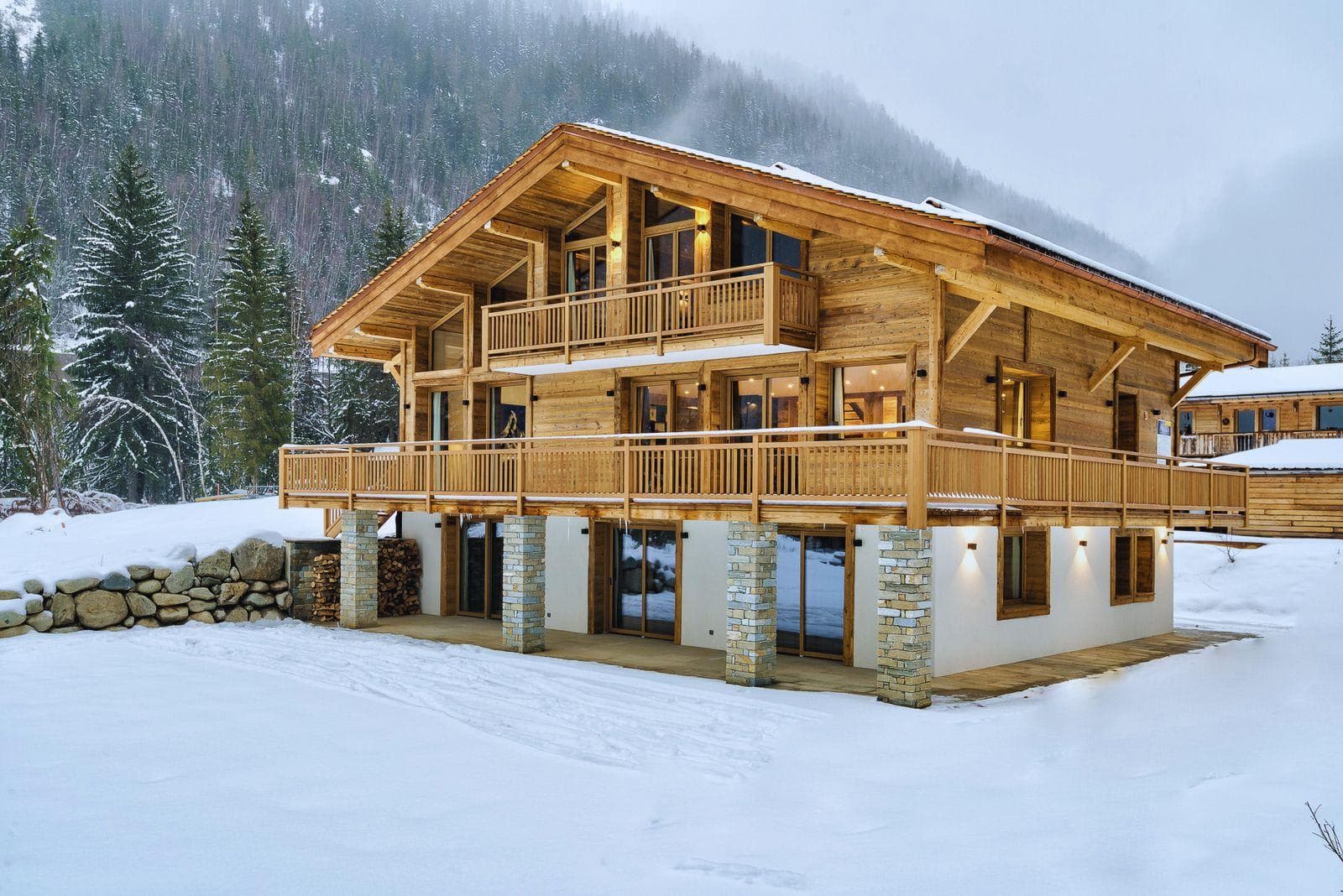 Ski-in chalet exterior featuring wrap-around balcony and mountain views
