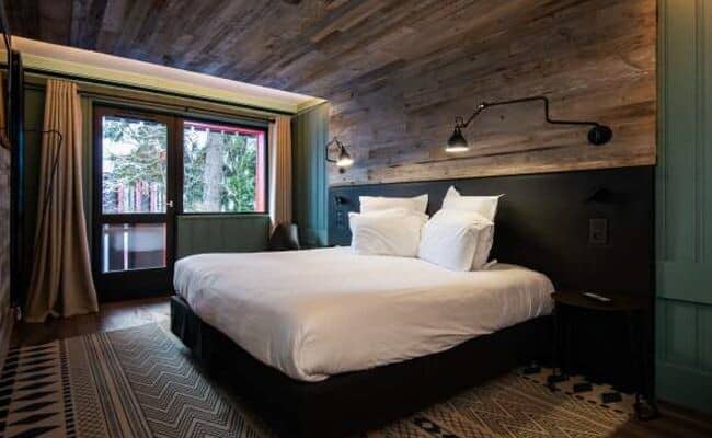 Bedroom with king bed and balcony access; reclaimed wood ceiling