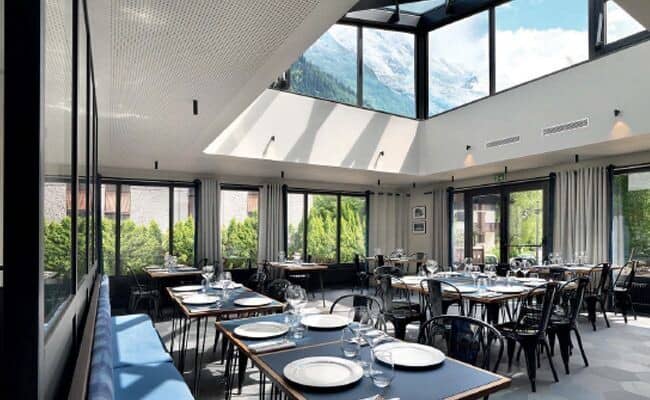 Dining area with glass atrium ceiling and mountain views