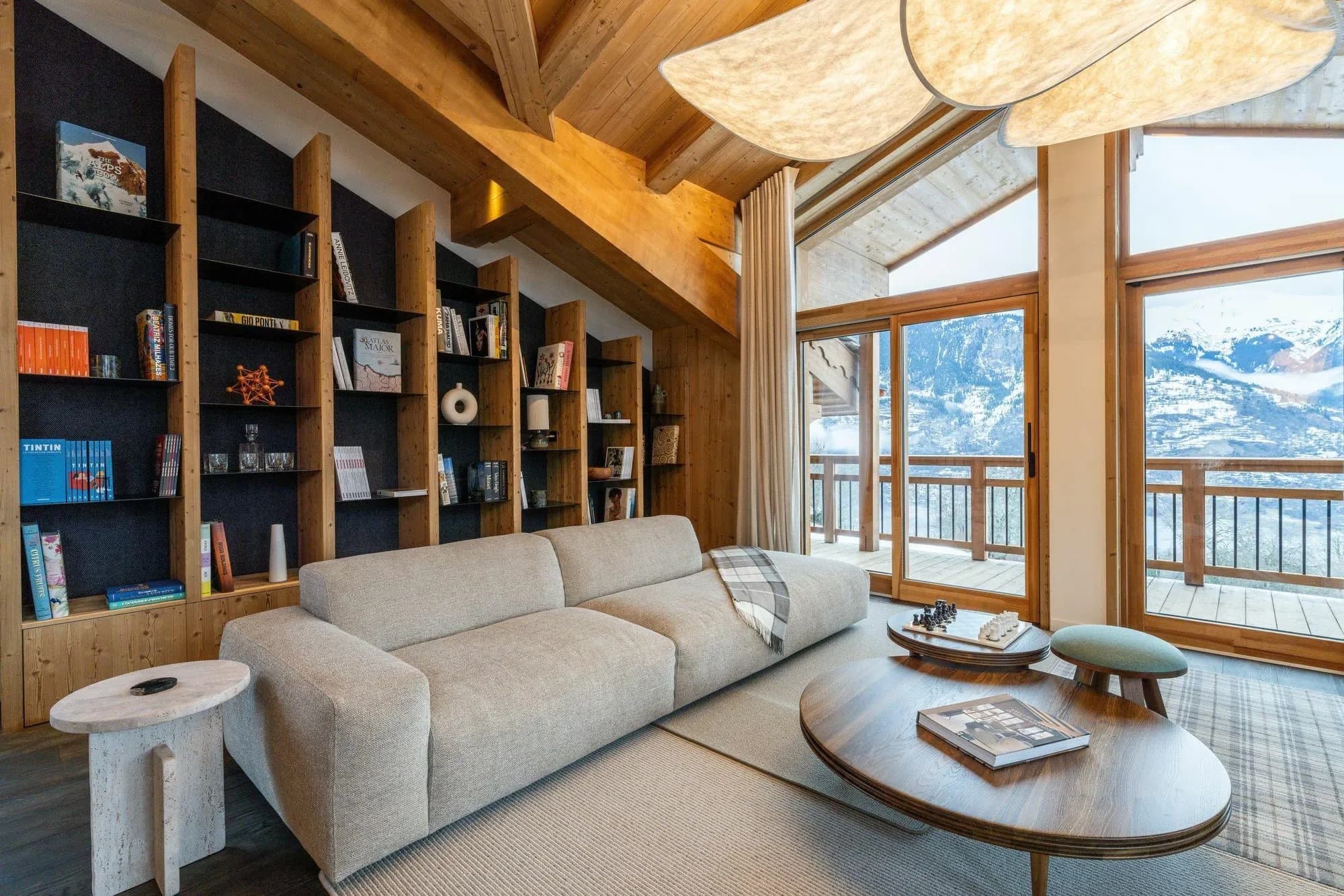 Living room seating beside floor-to-ceiling windows and balcony doors
