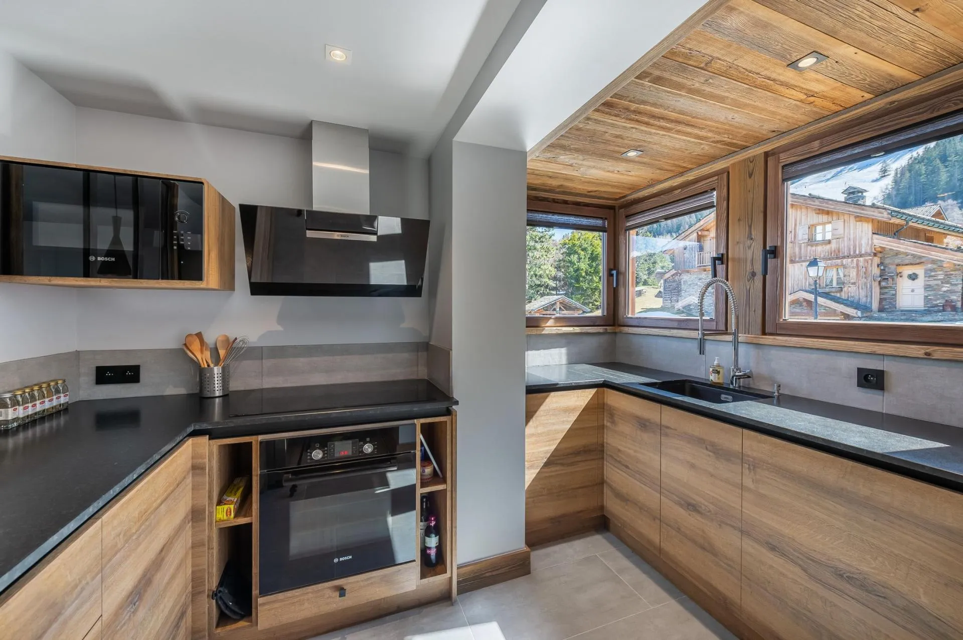 Closed fitted kitchen with oven, hob and mountain-facing window