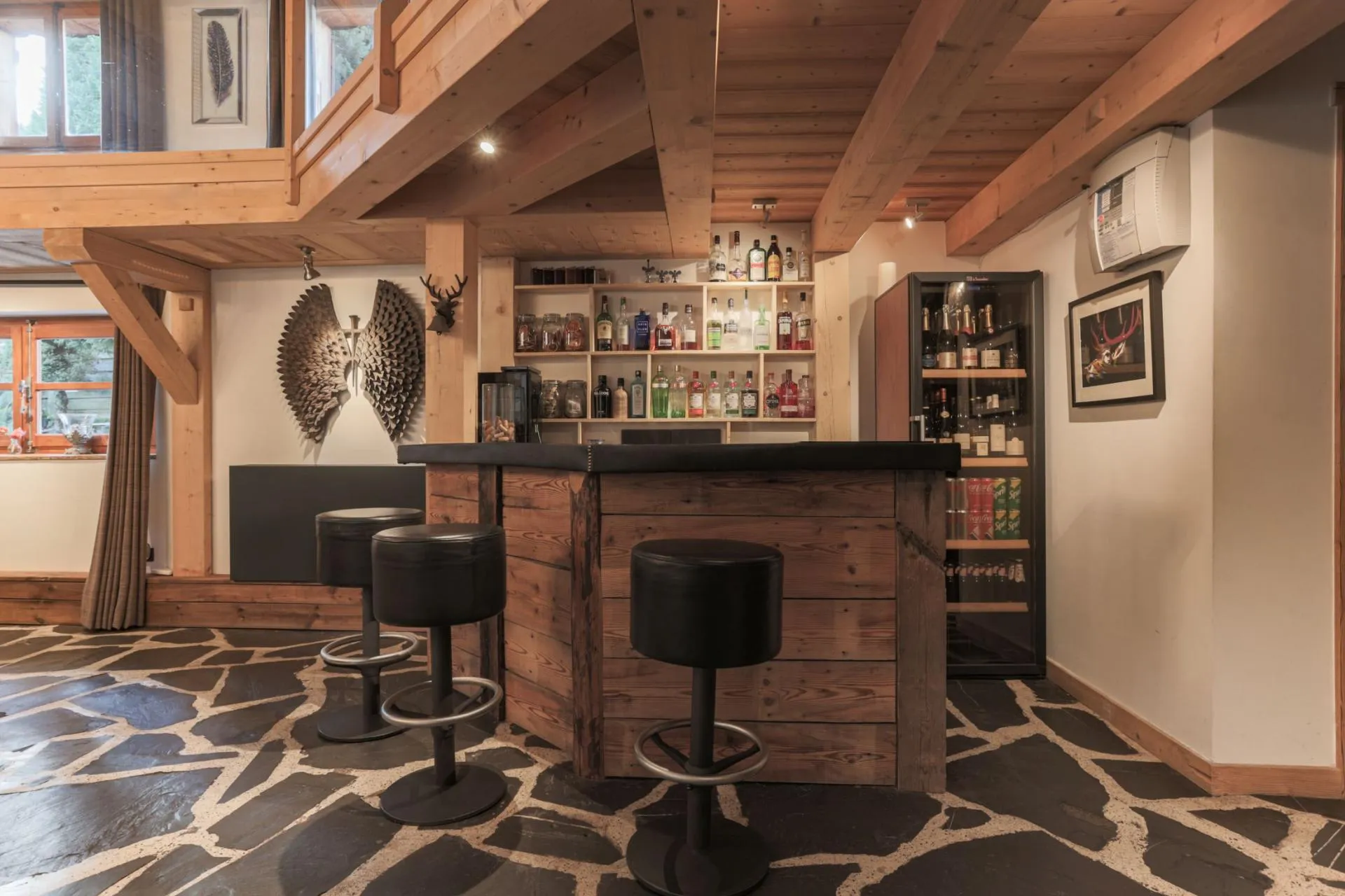 Timber guest bar with counter seating and drinks fridge