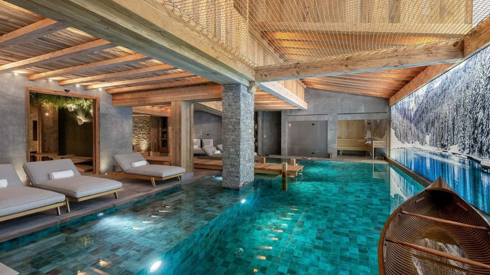 Indoor swimming pool with loungers, sauna access and an overhead relaxation net