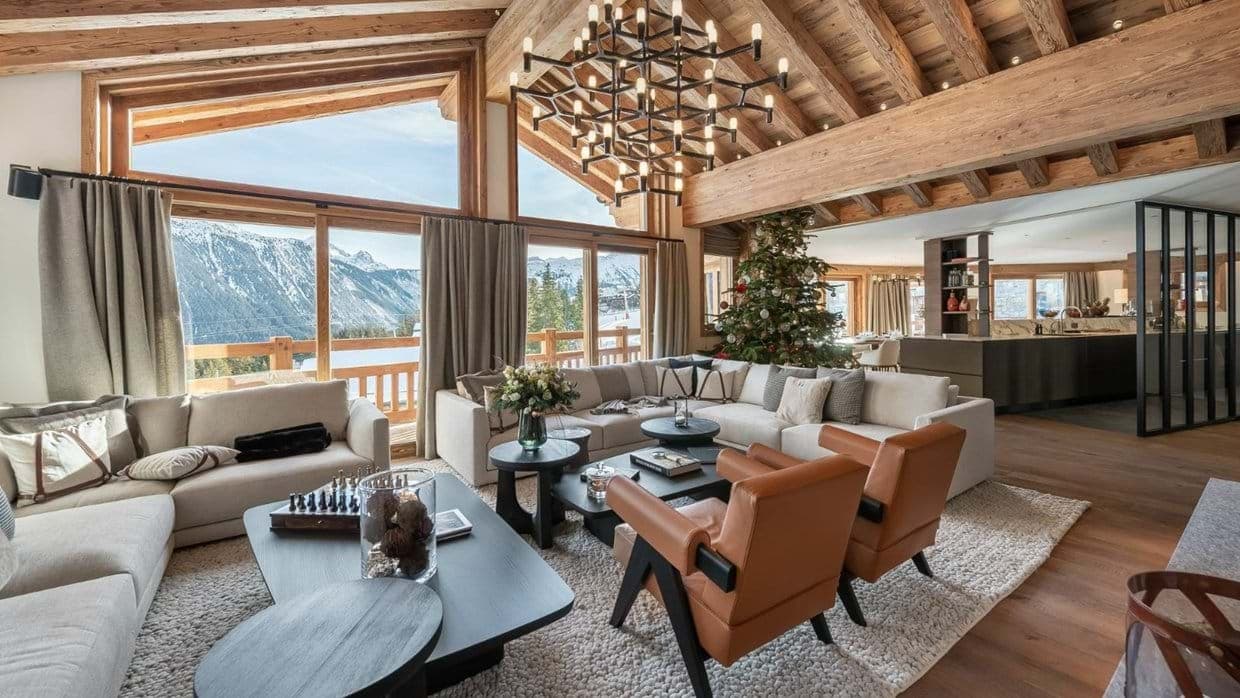 Open-plan living room with sectional seating, vaulted timber ceiling and mountain views