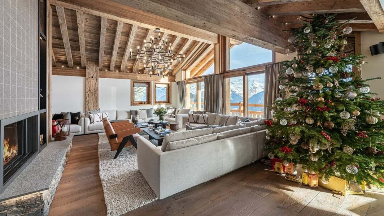 Living room with a wood fireplace, sectional seating and a decorated tree