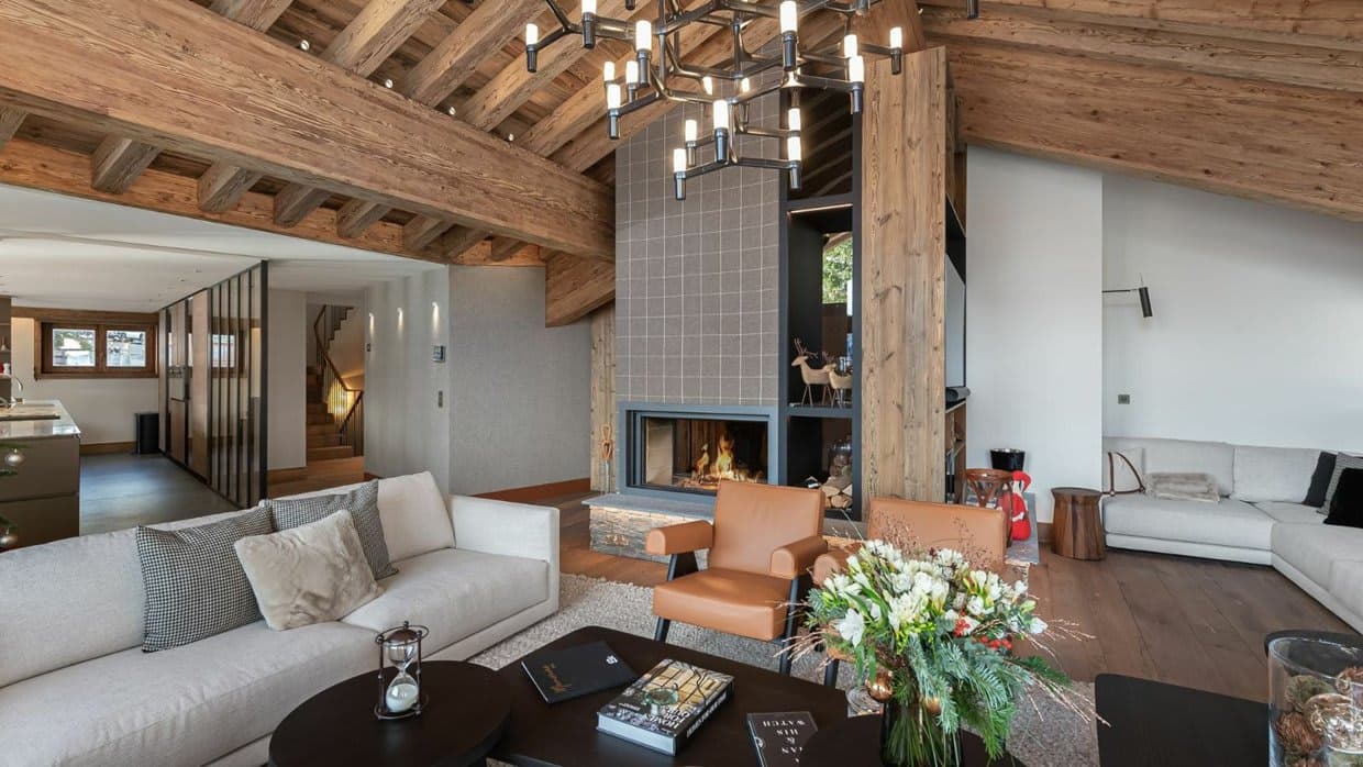 Vaulted living room with a wood fireplace, large windows and mountain views