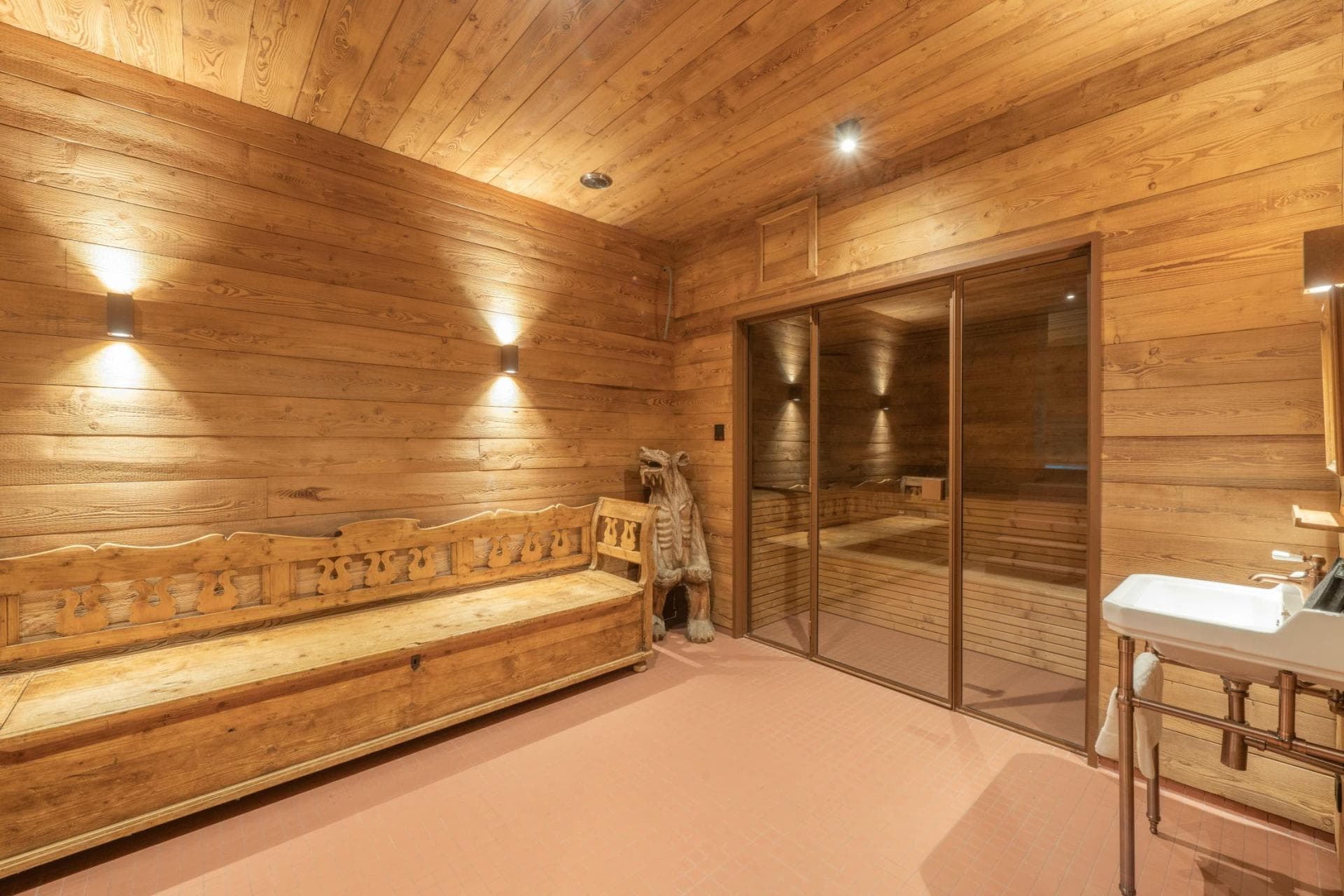 Private sauna with glass doors and a timber bench