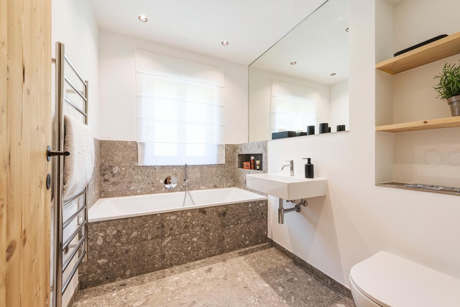Bathroom with heated towel rail and stone-wrapped soaking tub