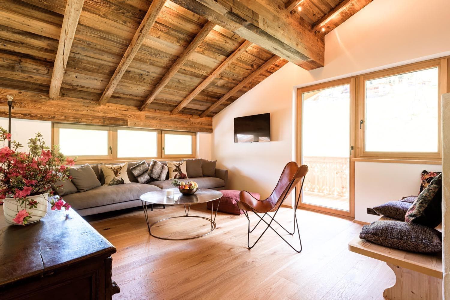 Upper-level living area with vaulted timber ceilings and balcony access