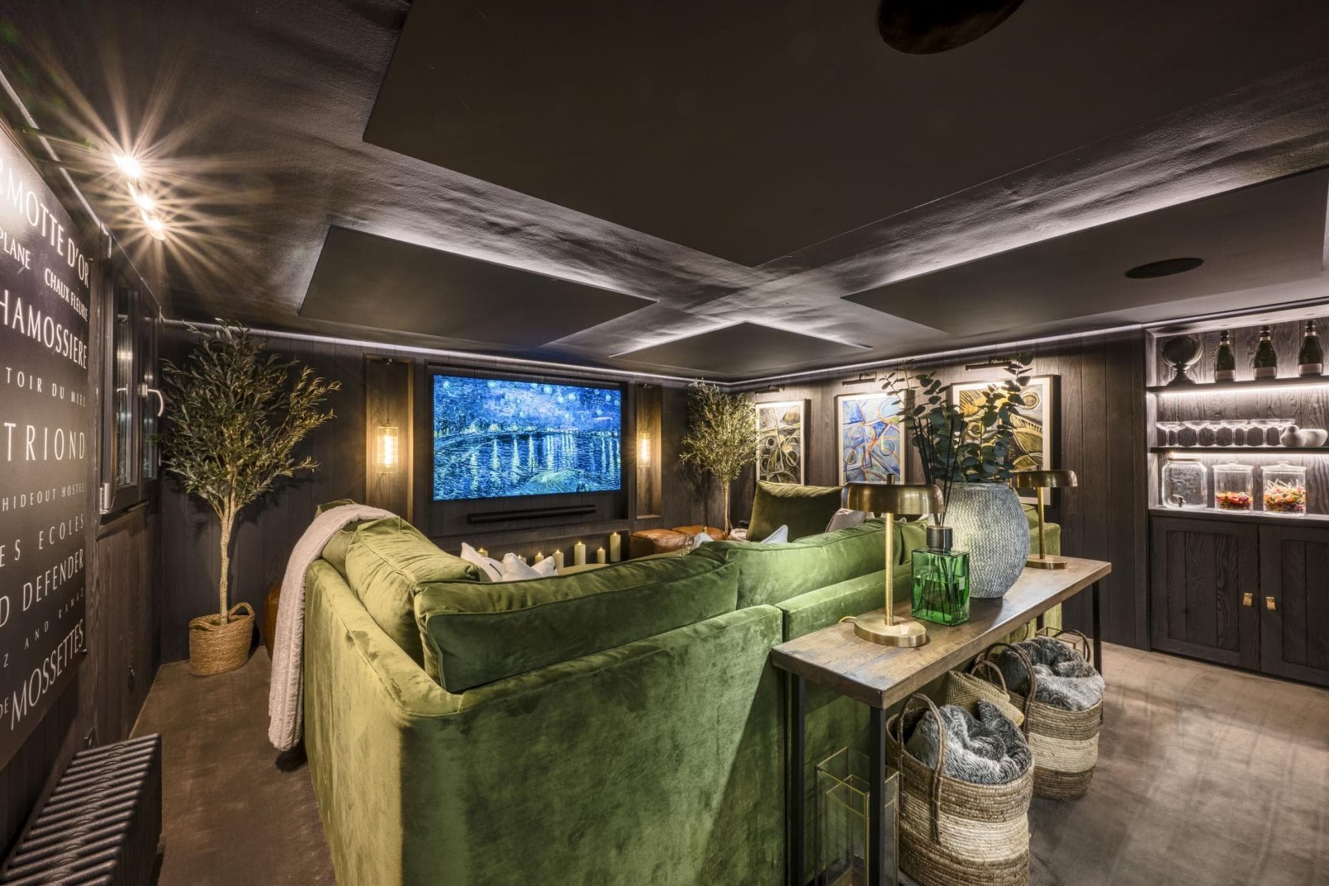 Cinema room with a large screen, sofa and mountain views