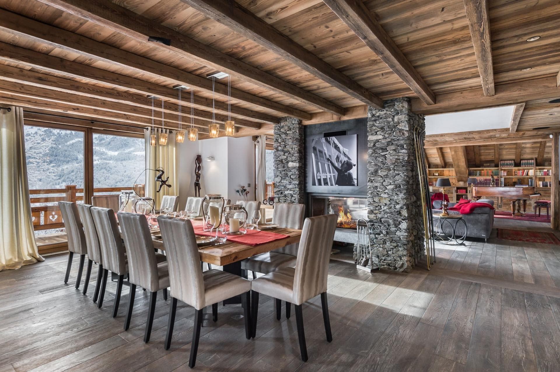 Dining area with mountain views and a central stone fireplace