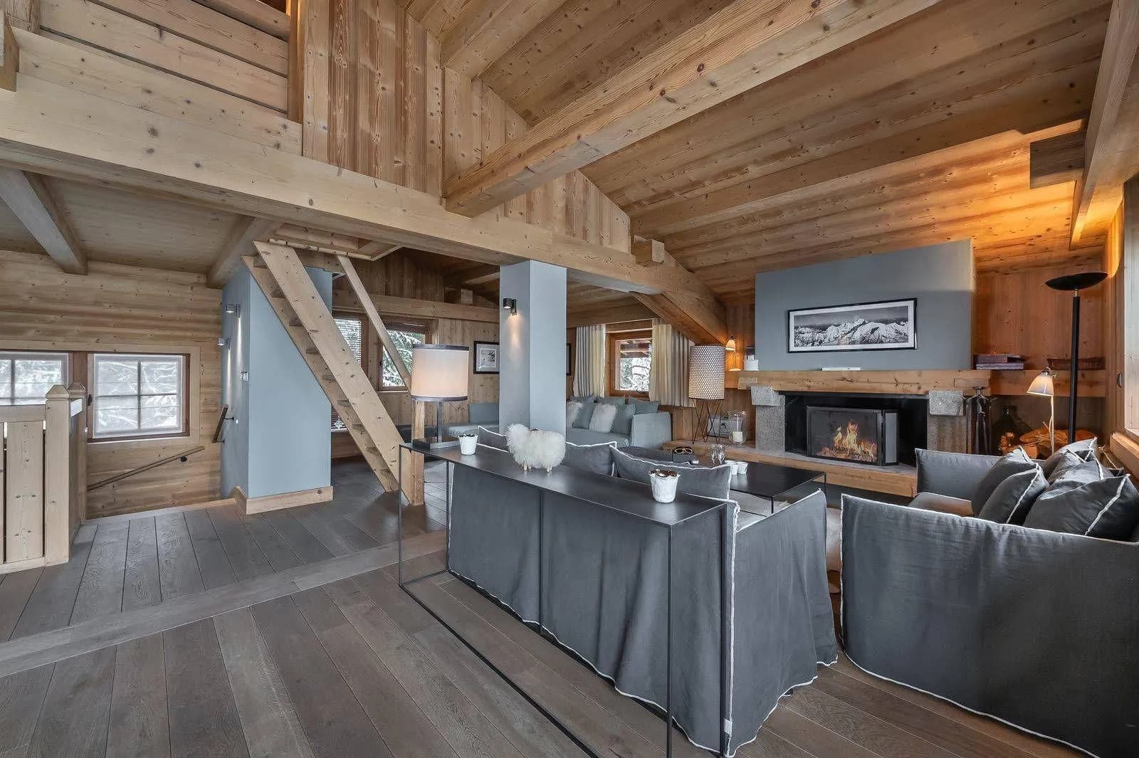 Top-floor living area with a wood fireplace and mezzanine above
