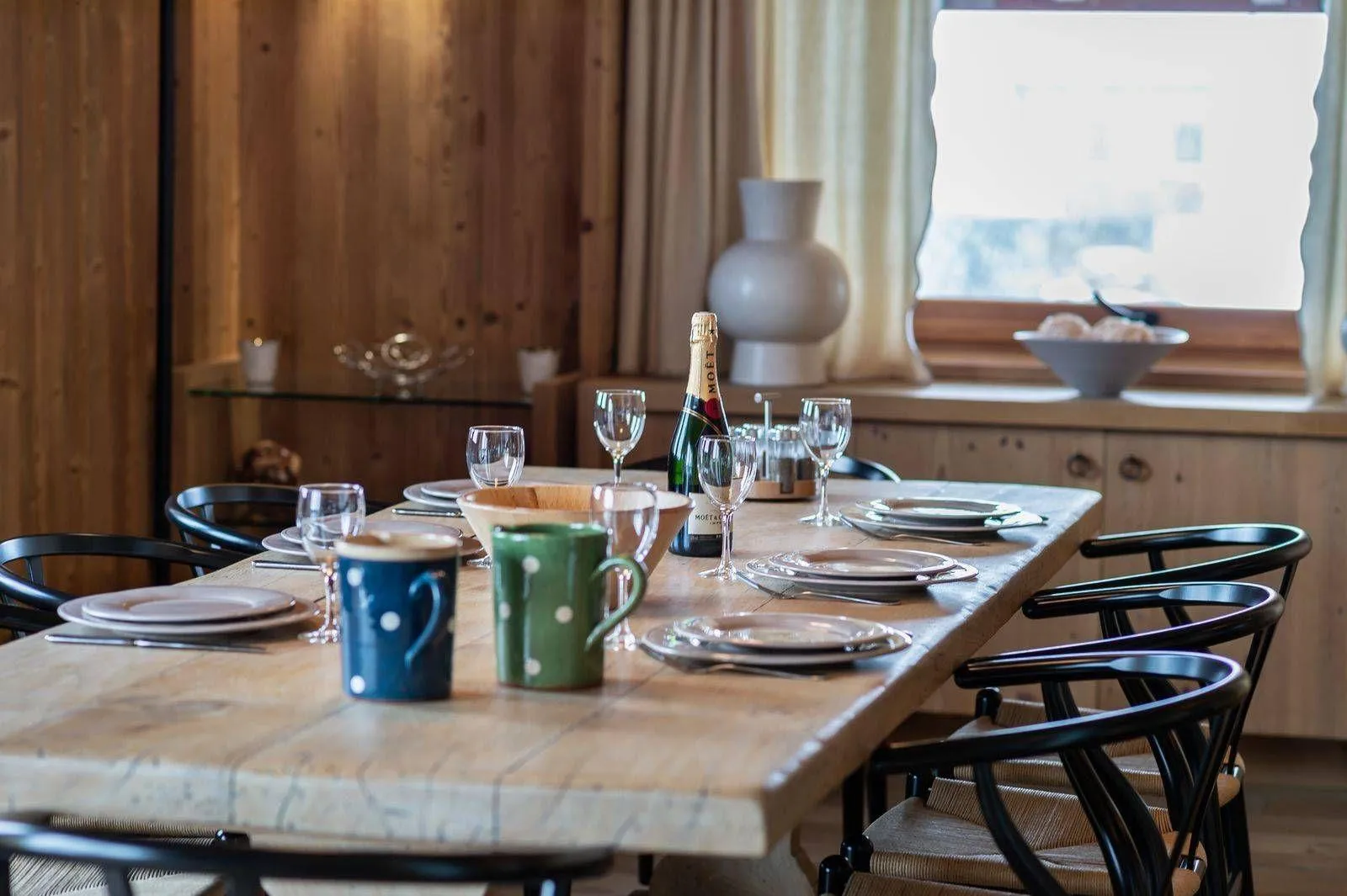 Dining area with a long timber table beside the living room