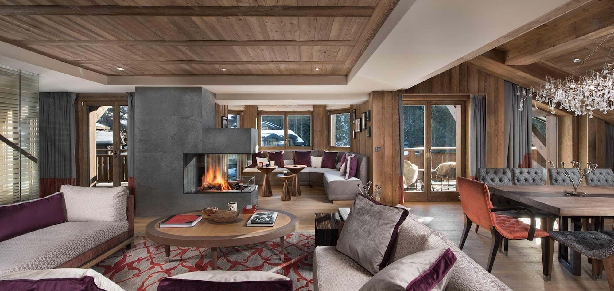 Open-plan living area with three-sided fireplace and balcony access