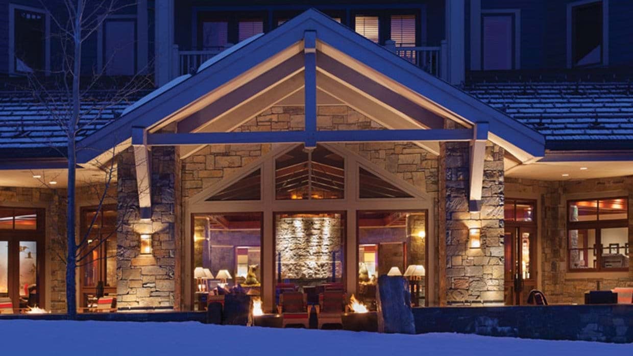 Stone patio with outdoor fire pits and views into the lodge