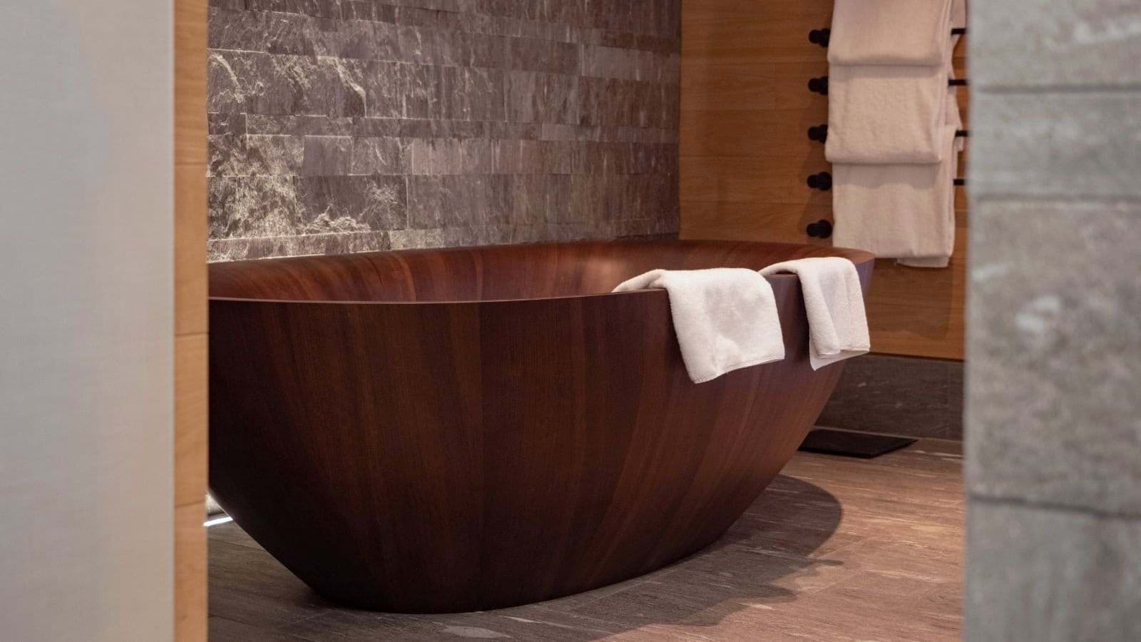 Bathroom with deep wooden soaking tub and heated towel rack