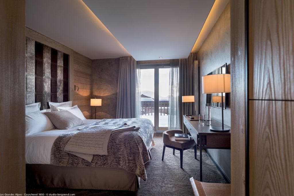 Primary bedroom with king bed, writing desk, and private balcony access