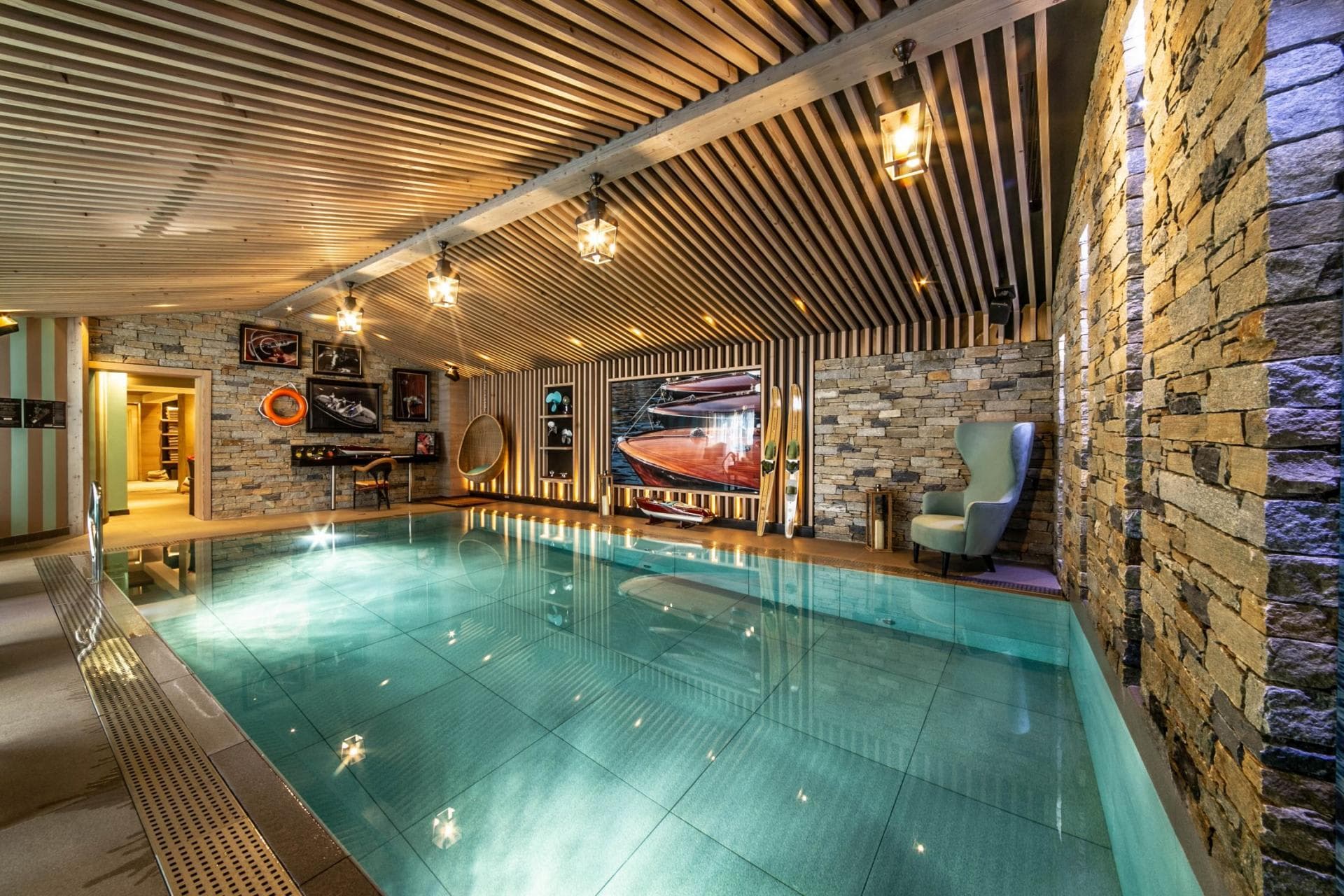 Indoor pool area with stone walls and slatted wood ceiling