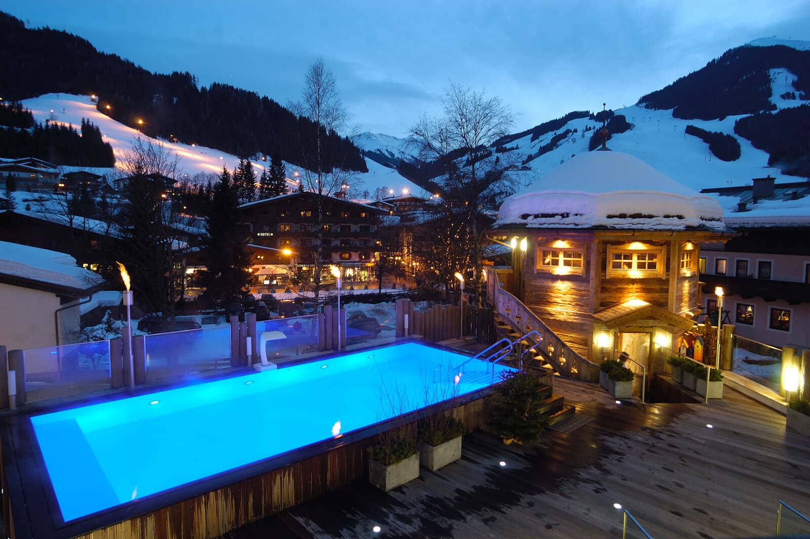 Heated outdoor pool and terrace with views of floodlit ski slopes