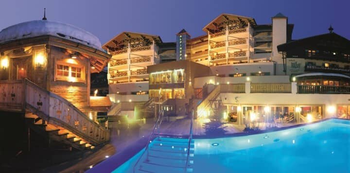 Heated outdoor pool and hot tub area with alpine lodge views