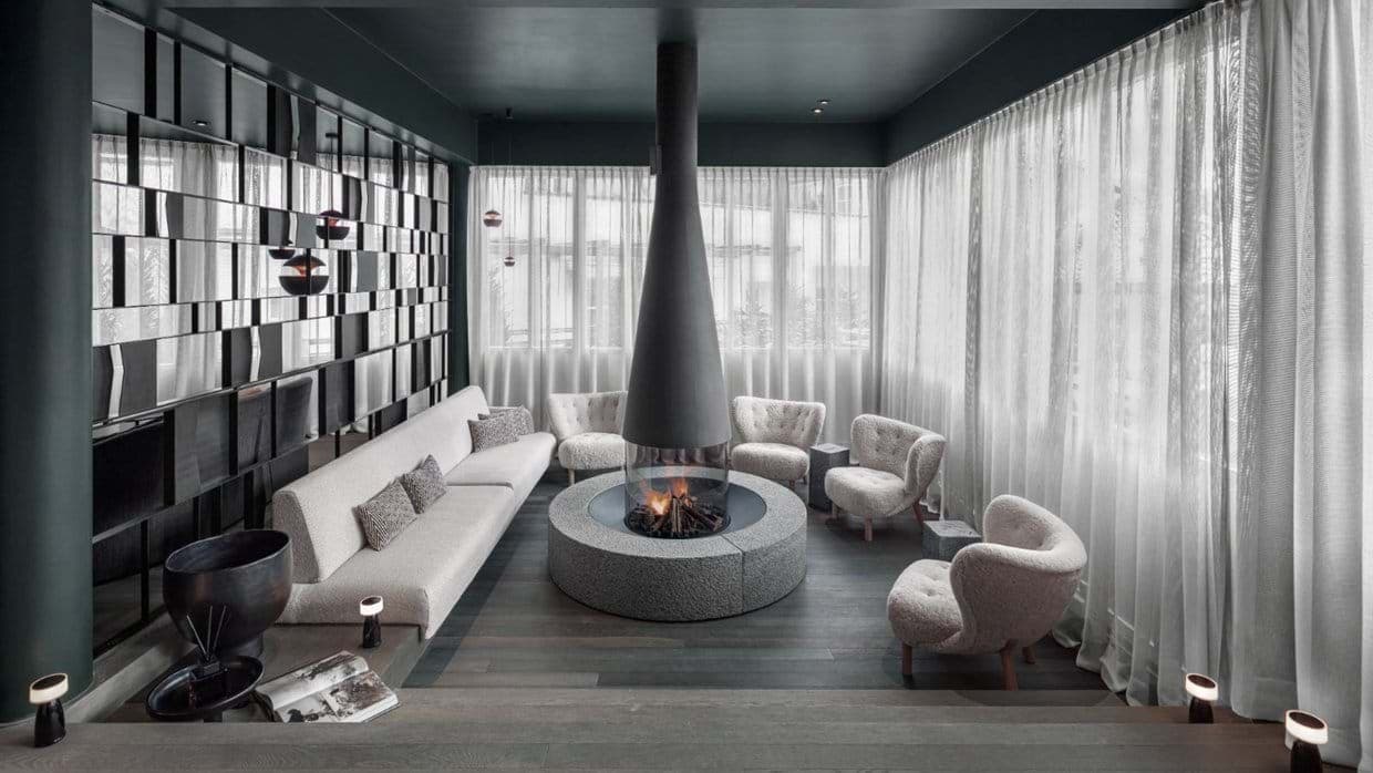 Lounge with central circular wood fireplace and seating for 8