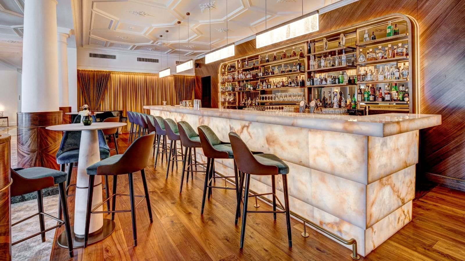 Backlit stone bar with seating for 10 and coffered ceiling detail