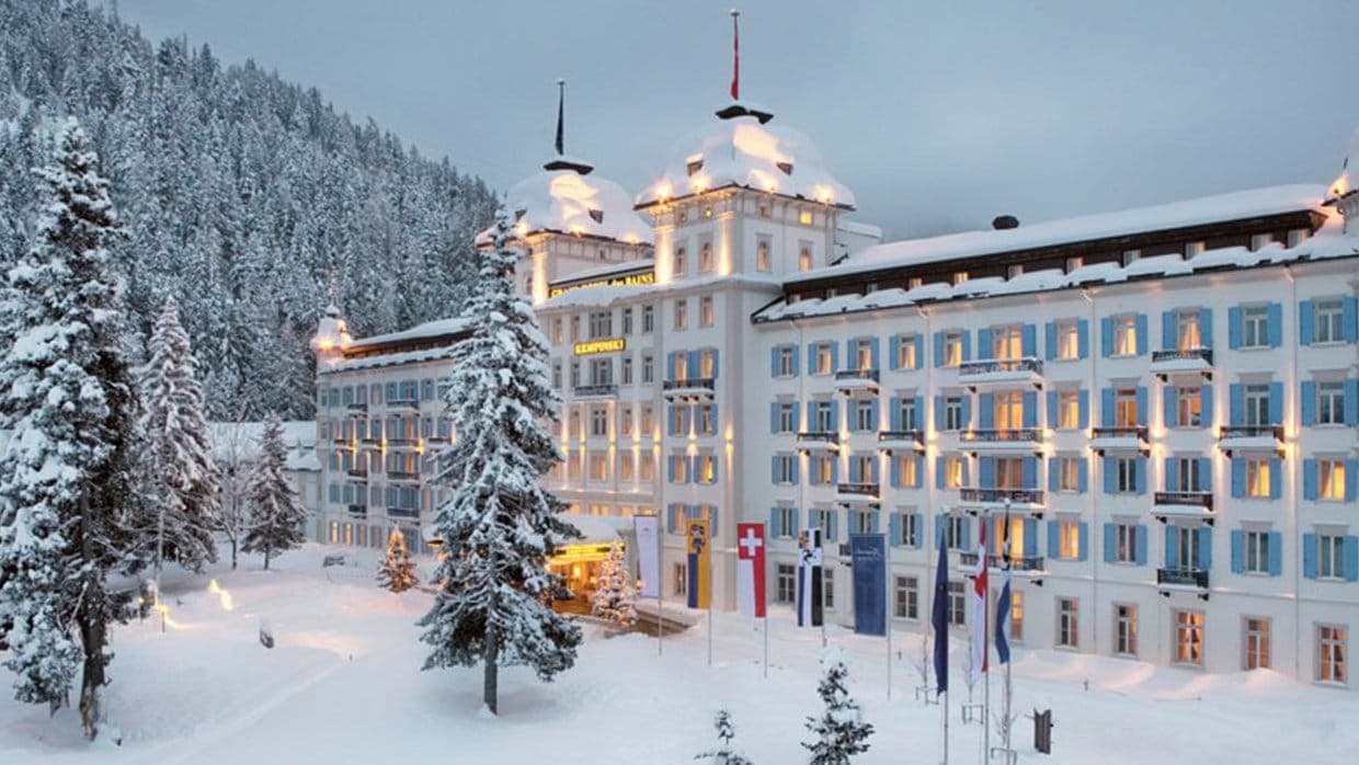 Ski-in access resort exterior with snow-covered grounds and mountain backdrop