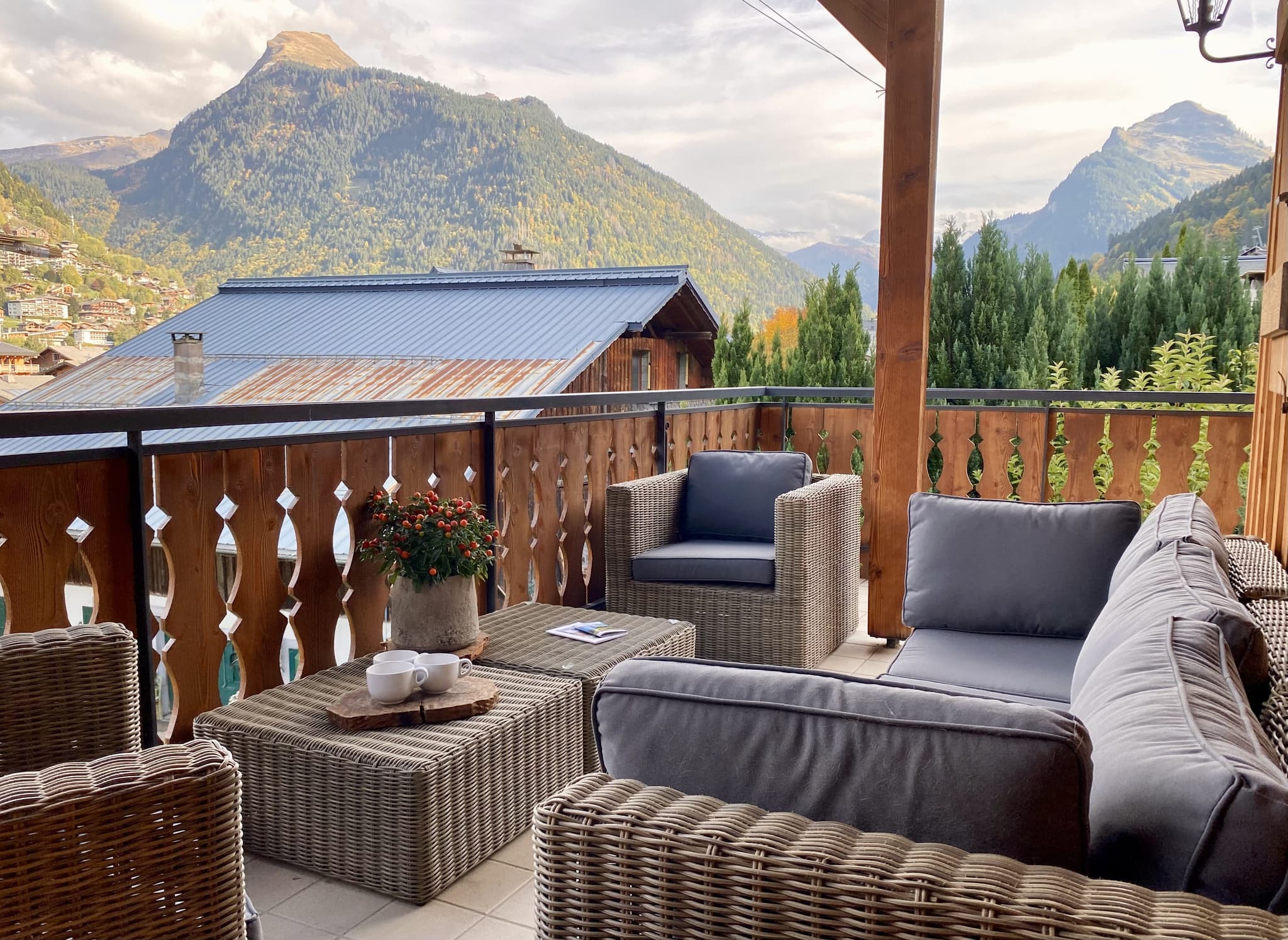 Balcony with wicker seating, mountain views, and decorative railing detail