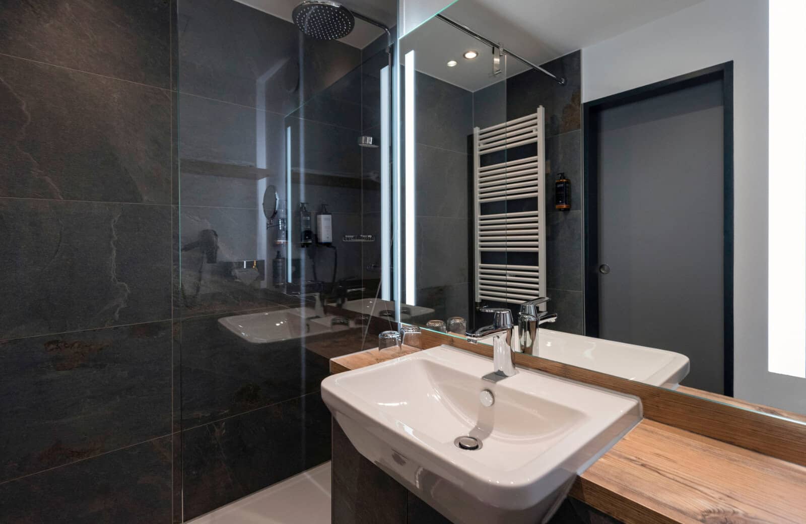 Bathroom with walk-in rainfall shower and heated towel rack