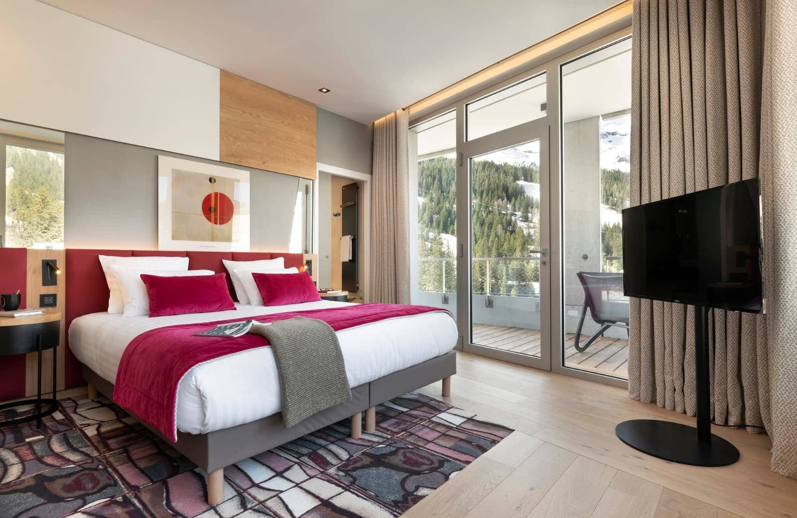 Primary bedroom with king bed and private balcony overlooking pine forest