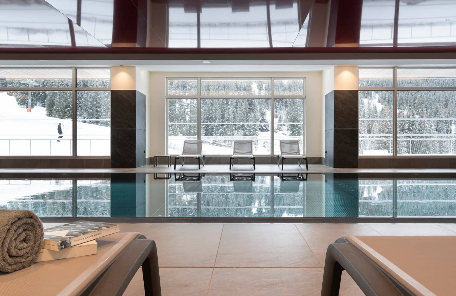 Indoor heated pool with poolside loungers and ski-in/ski-out views