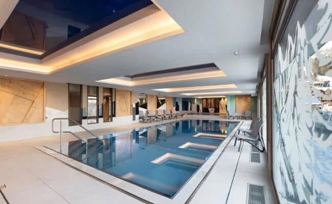 Indoor lap pool with step entry and poolside lounge seating
