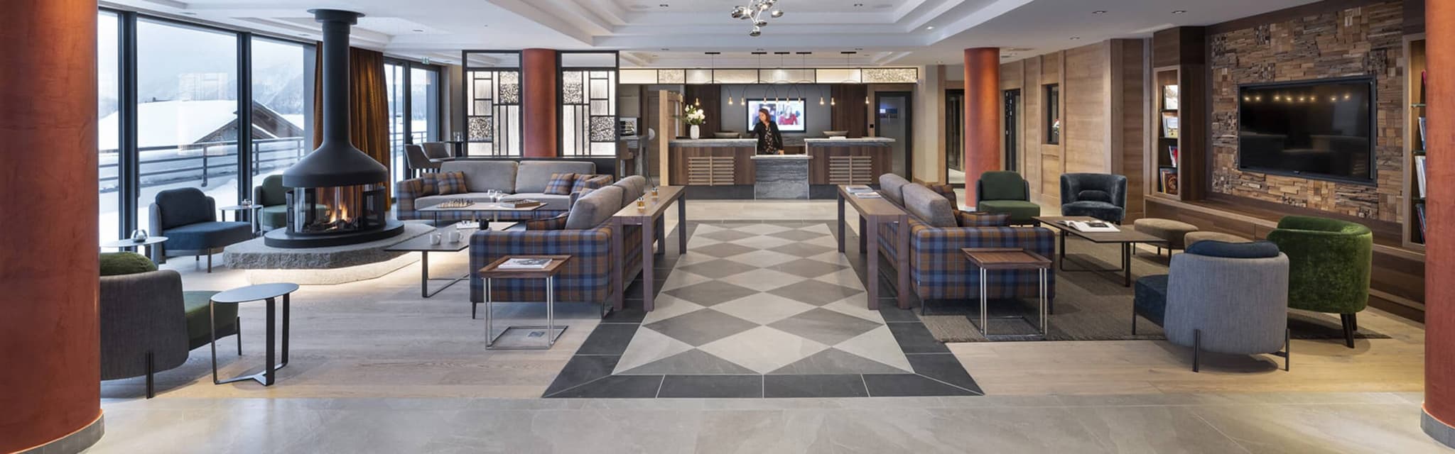 Lounge with central fireplace, multiple seating areas, and mountain-facing balcony