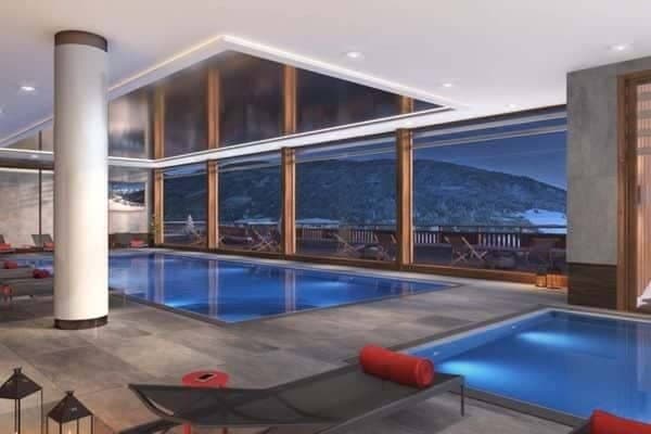 Indoor pool and hot tub with mountain views and terrace access