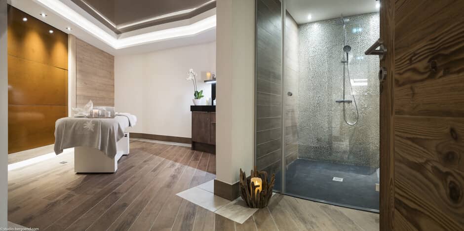 Private spa room with massage table and walk-in rainfall shower