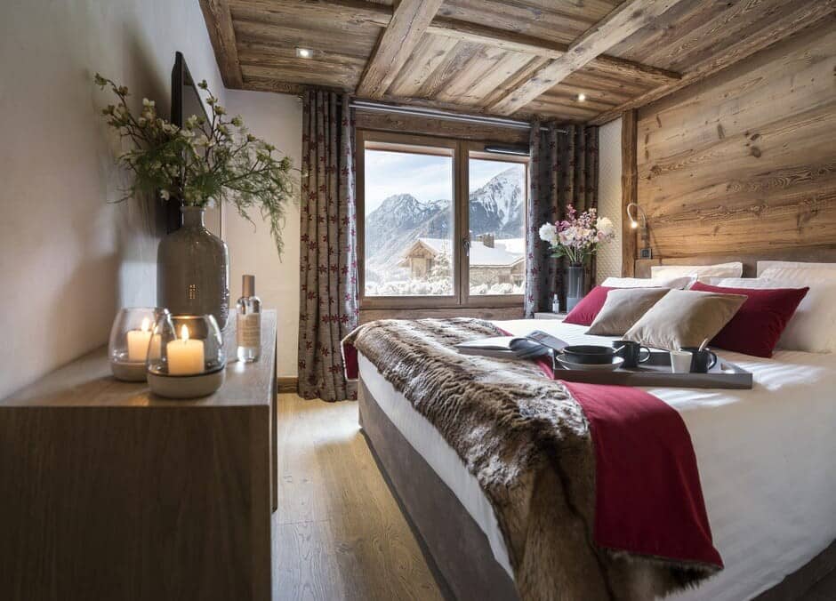 Primary bedroom with reclaimed wood walls and alpine mountain views
