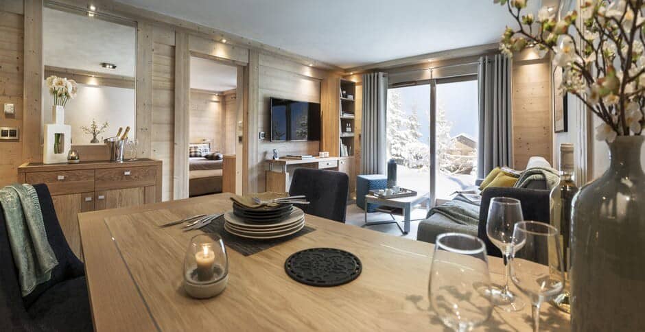 Open-plan living and dining area with snowy mountain balcony views