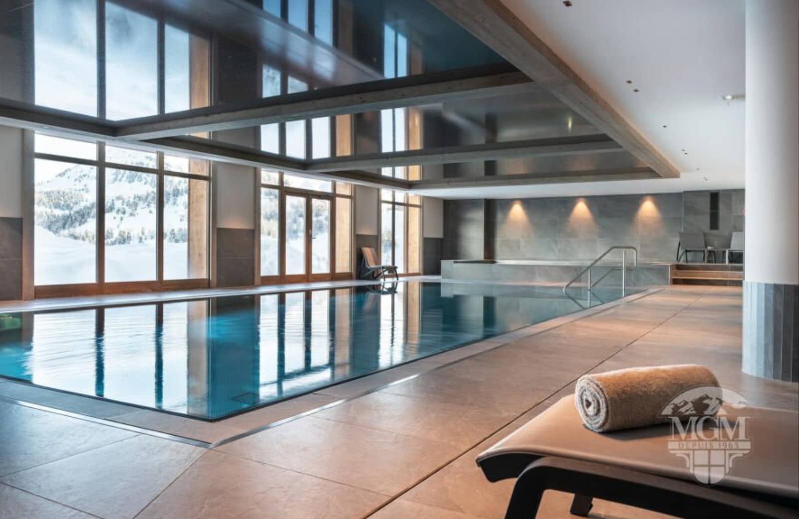 Indoor heated pool with mountain views and adjacent hot tub