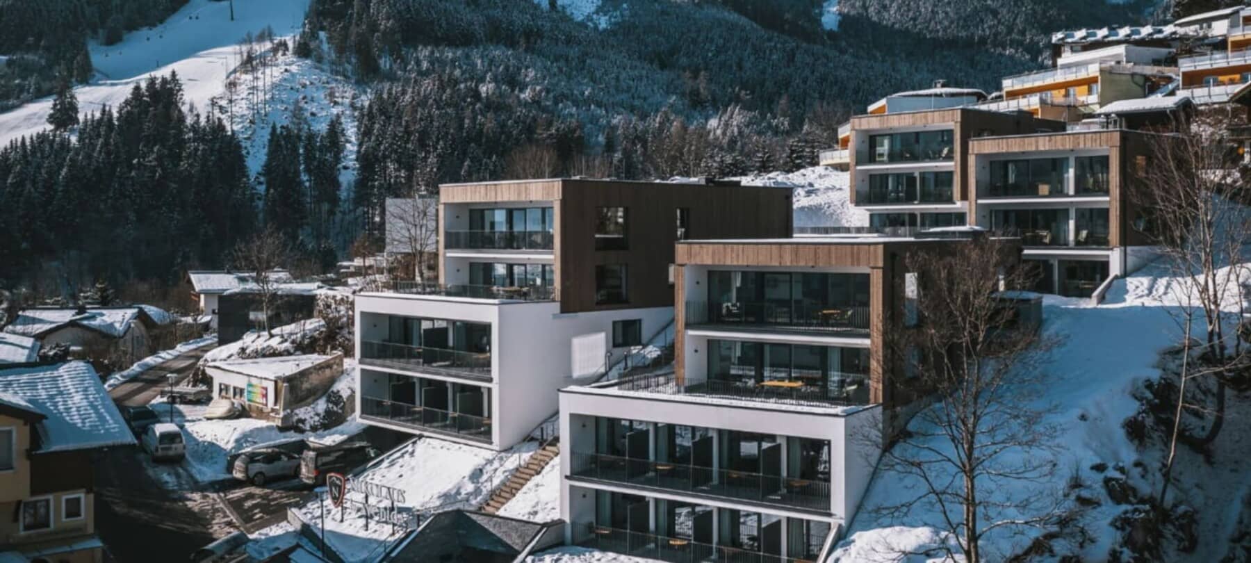 Slope-side apartment building with private balconies and direct access to trails