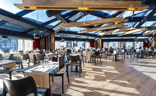 Glass-walled dining room with mountain views and atrium ceiling
