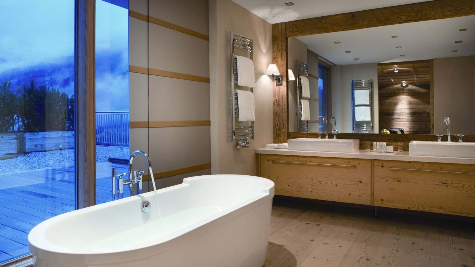 Primary bathroom with dual vanity, soaking tub, and heated towel rack