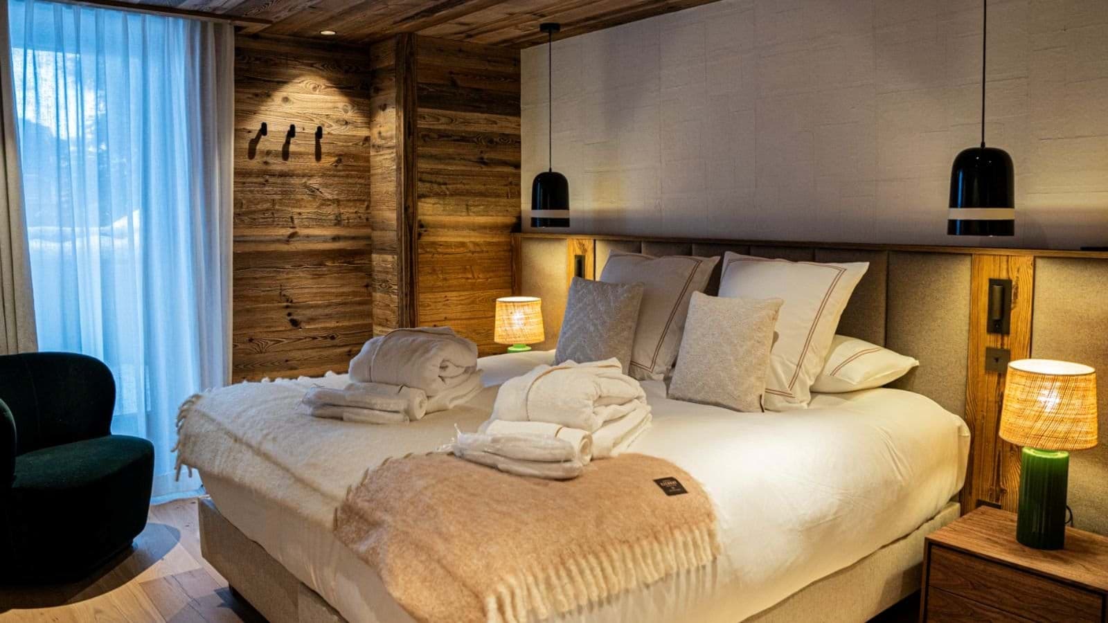 Primary bedroom with king bed, reclaimed wood walls, and terrace access