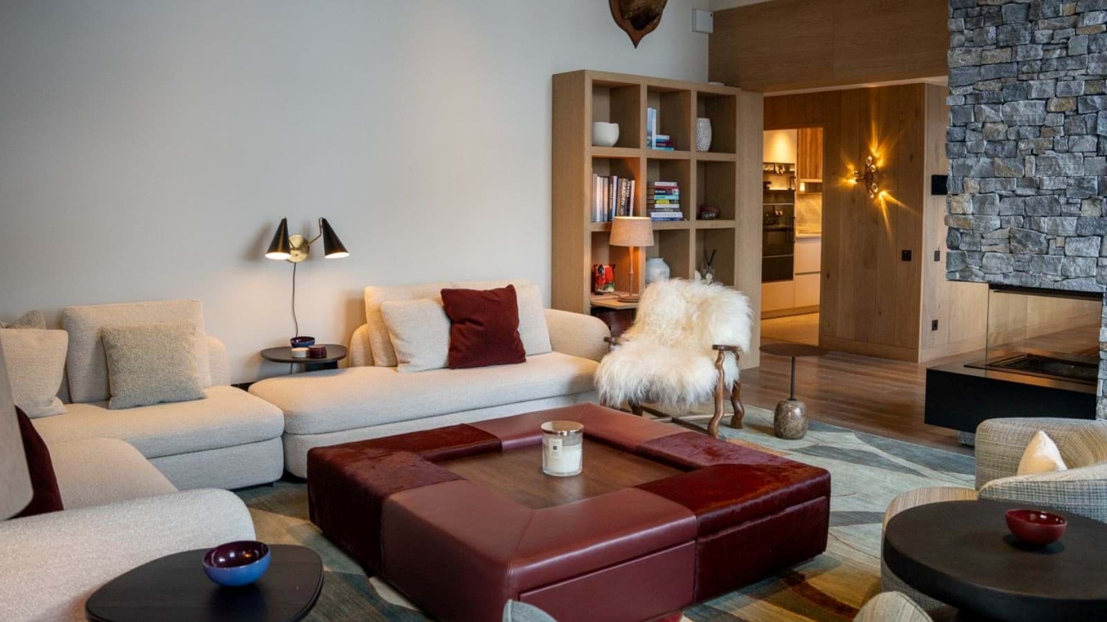 Living area featuring stone fireplace and leather ottoman seating