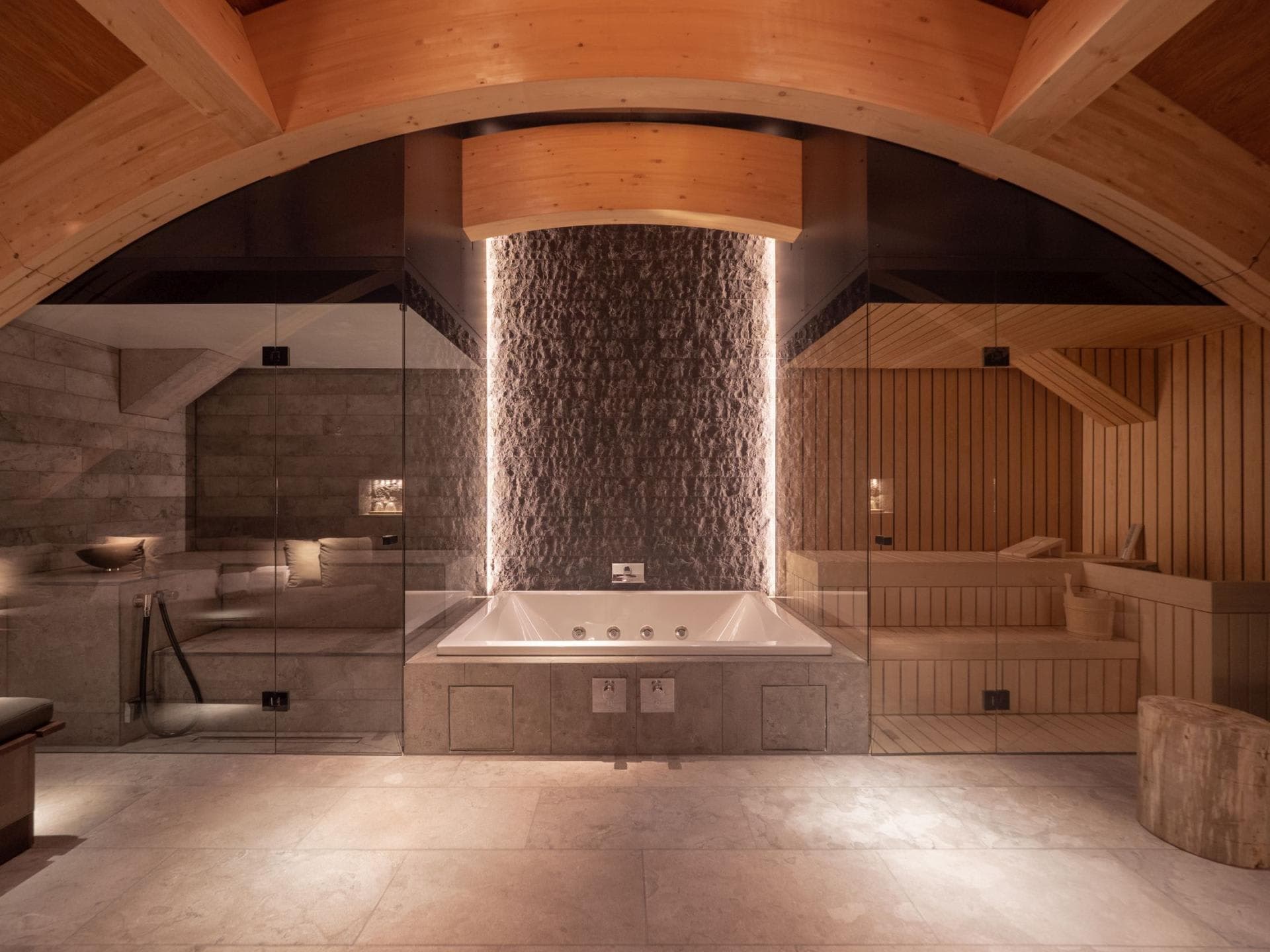 Spa area with jetted soaking tub, glass-enclosed sauna, and steam room