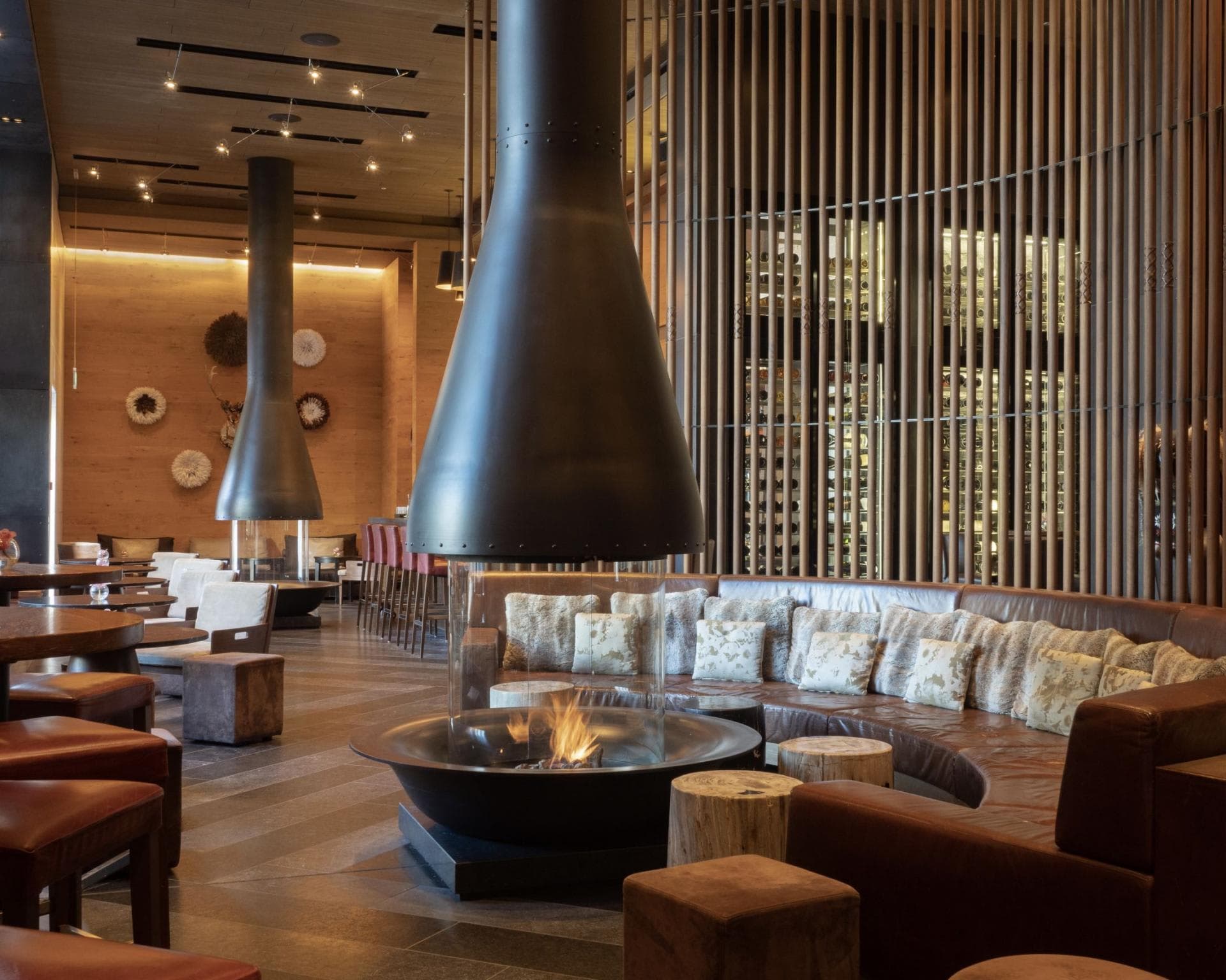 Lounge with wood-burning fireplace, leather sectional, and floor-to-ceiling wine storage