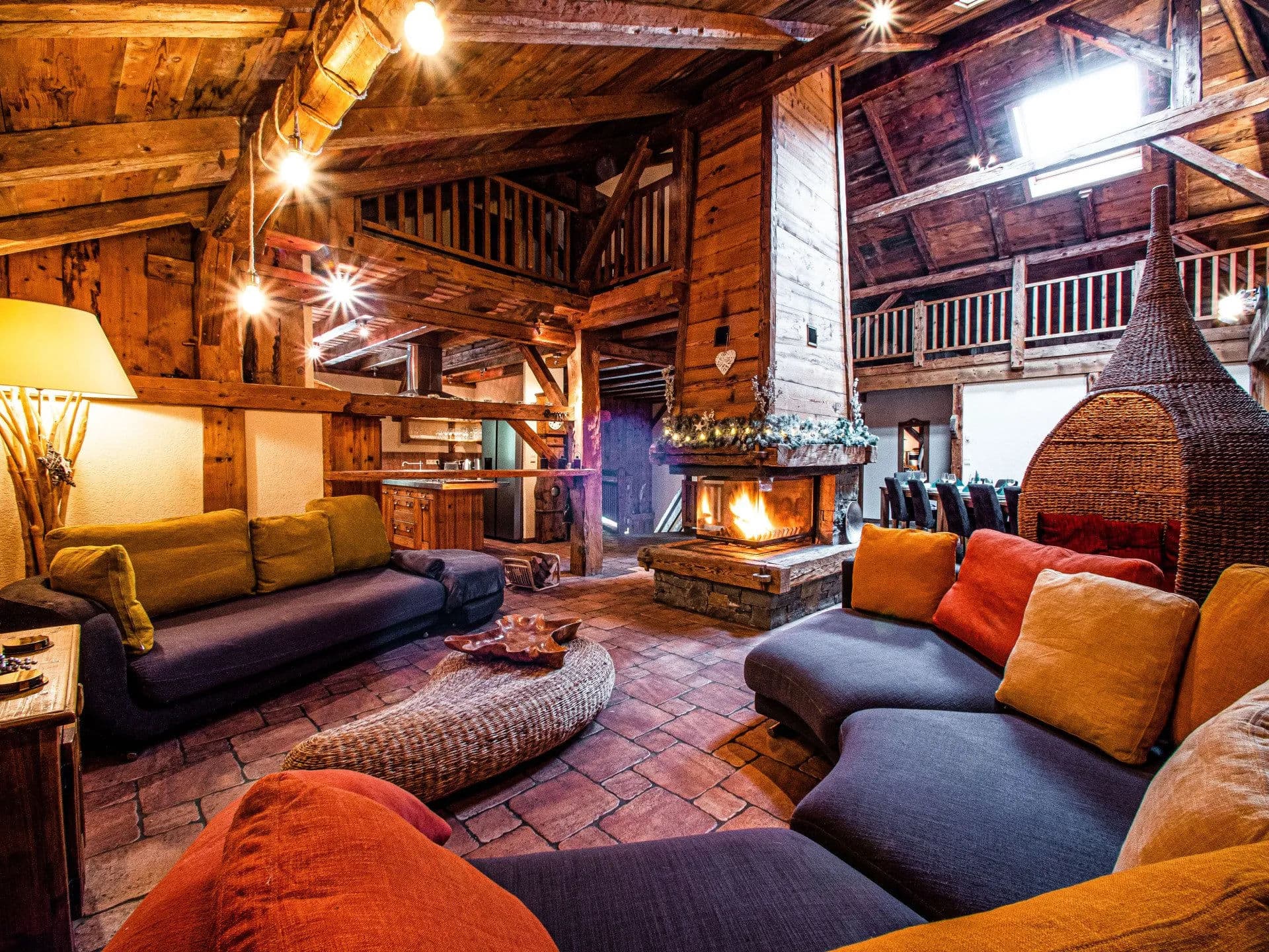 Great room with wood beams, central fireplace, and seating for 12+