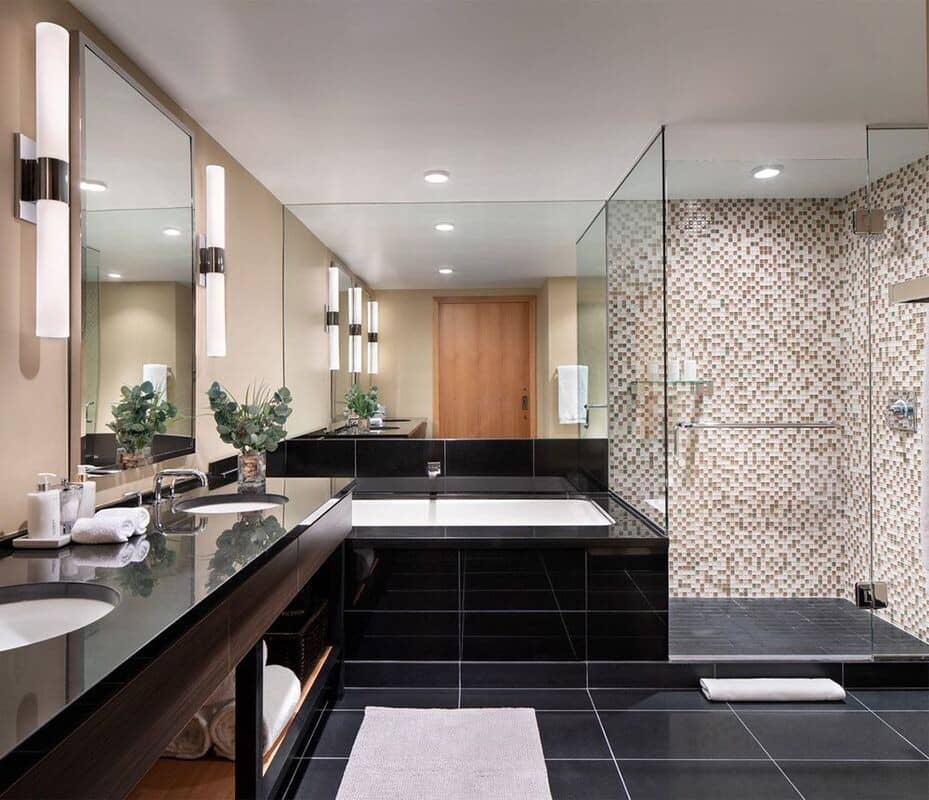 Bathroom with dual-sink vanity, soaking tub, and walk-in glass shower