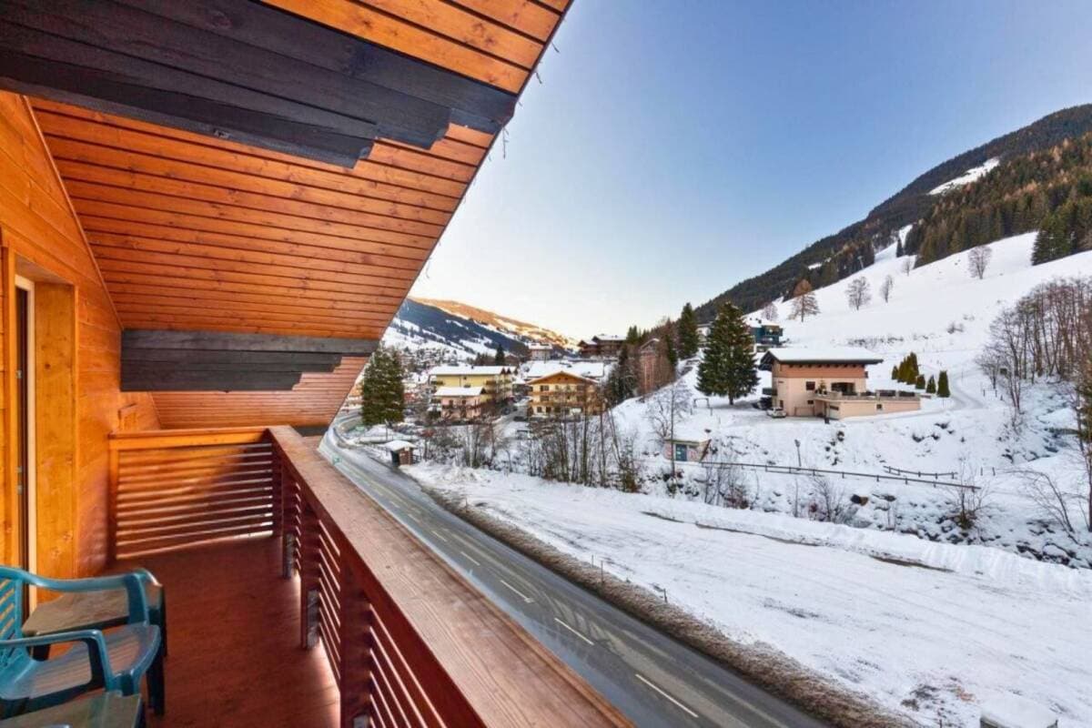 Balcony with valley and ski slope views; road and village below